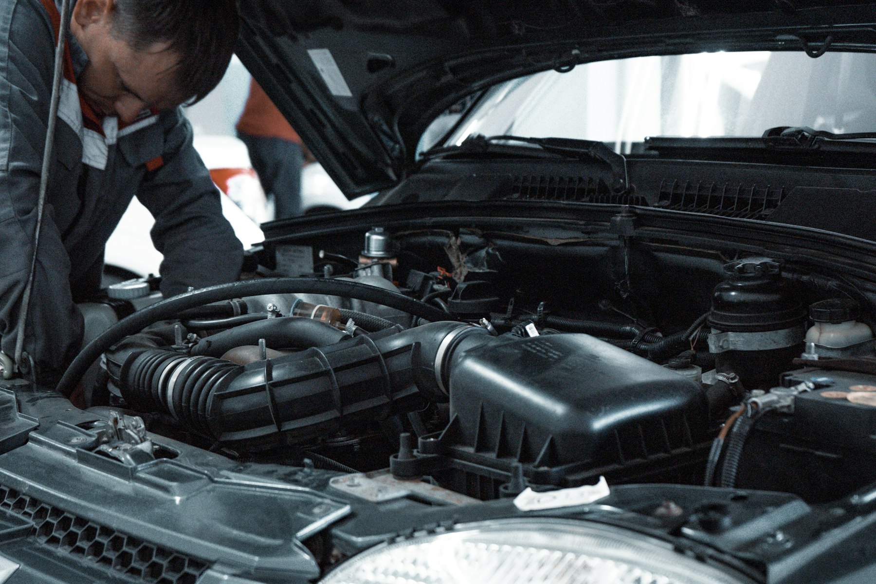 Bilmekaniker inspekterar motorn under service